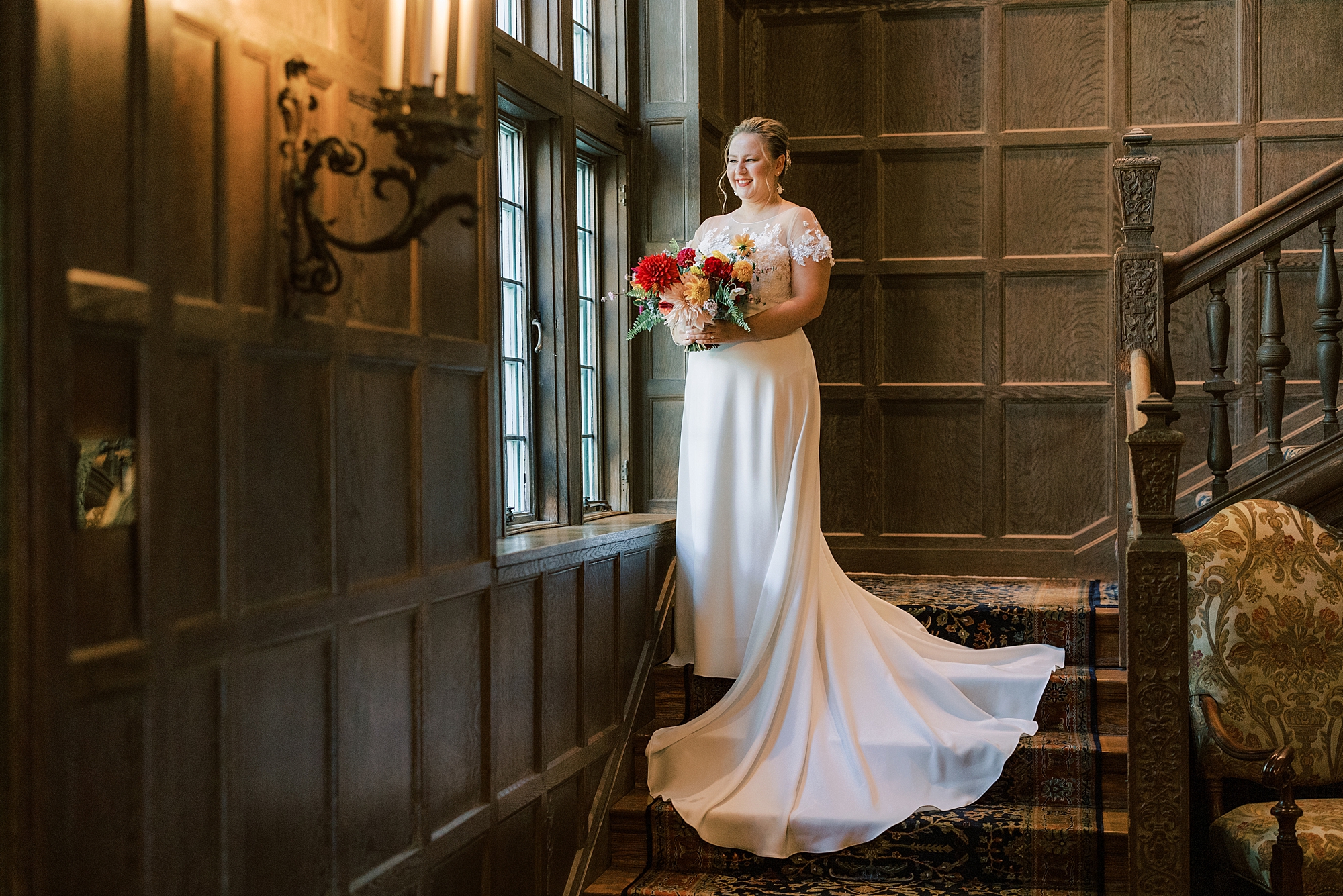 bride stands on staircase along wooden walls at Greenville Country Club
