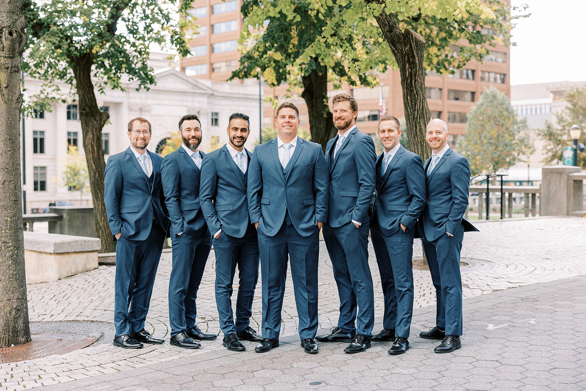 groom stands with groomsmen in navy suits in Wilmington 