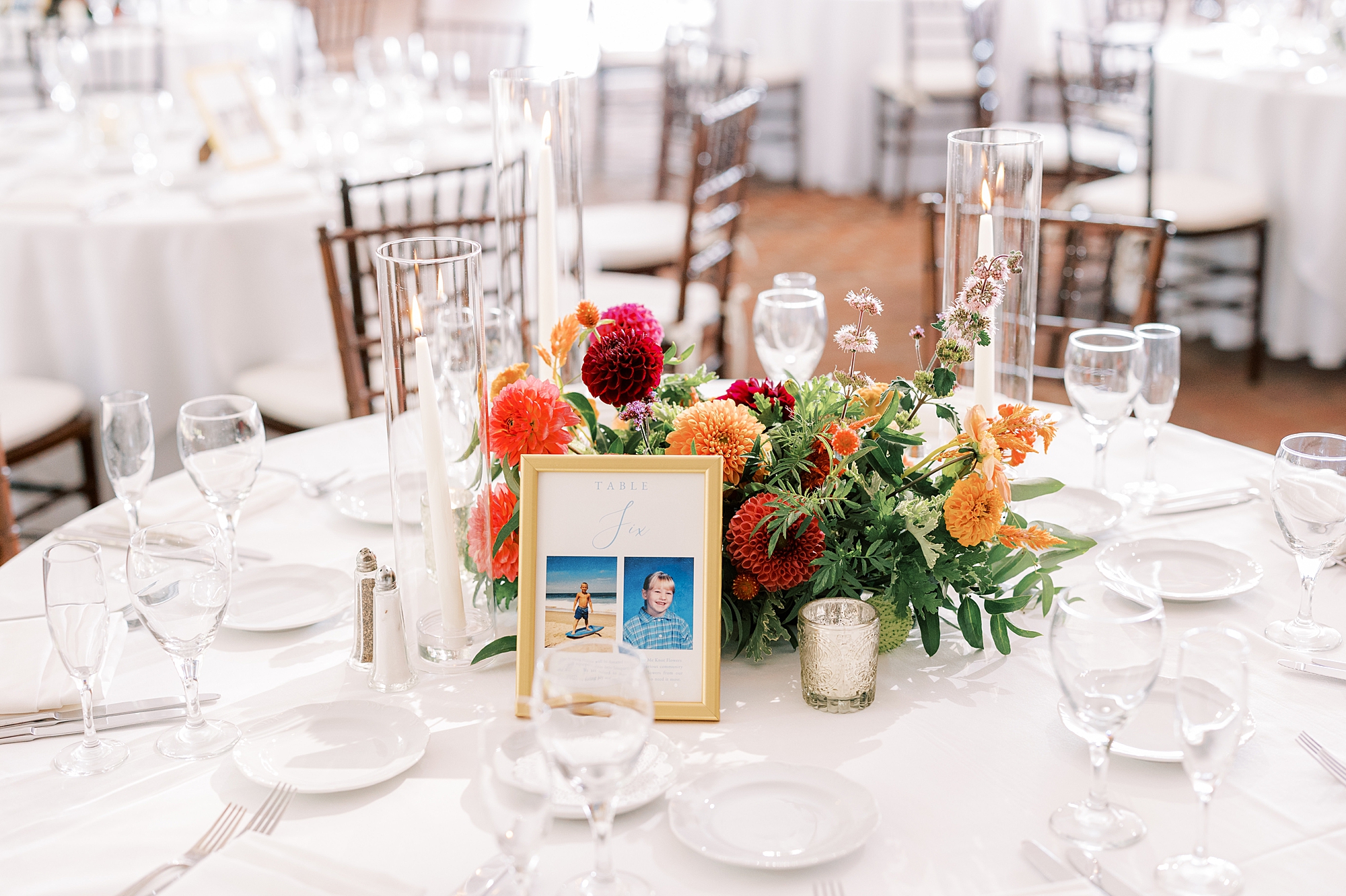 centerpieces with red and orange flowers with gold frames 
