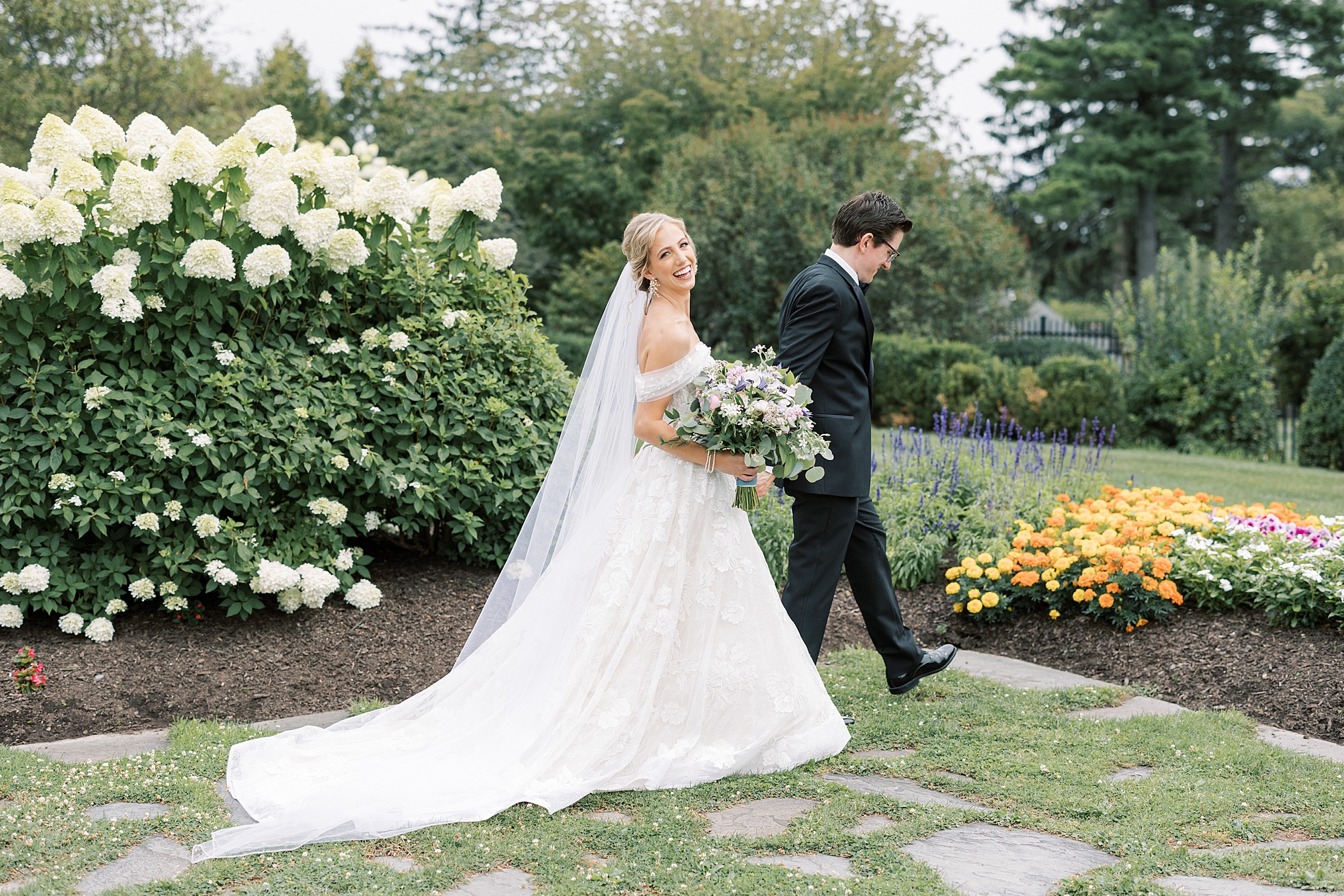 groom leads bride through gardens at Skytop Lodge
