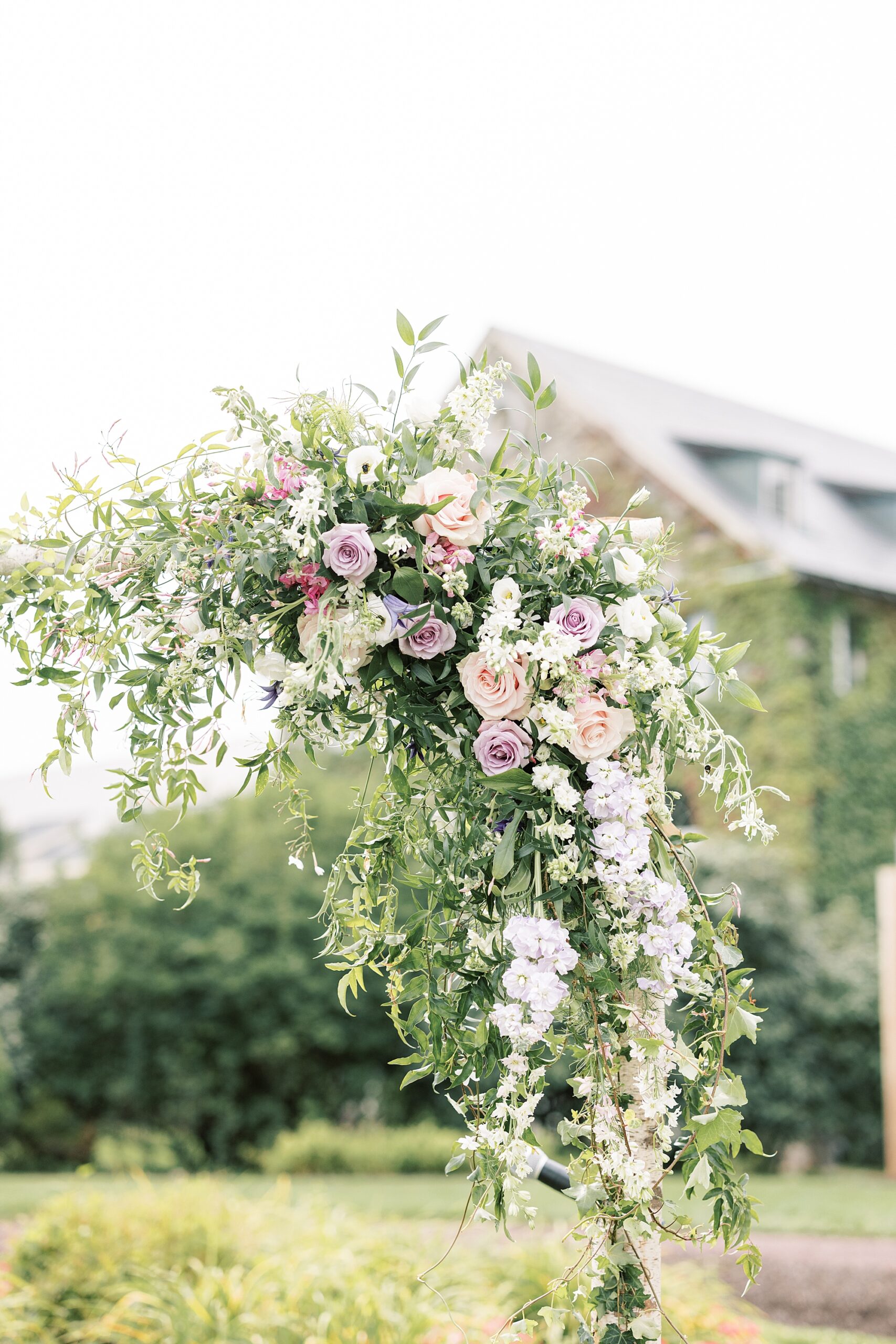 wedding ceremony with white and pink flowers on arbor 