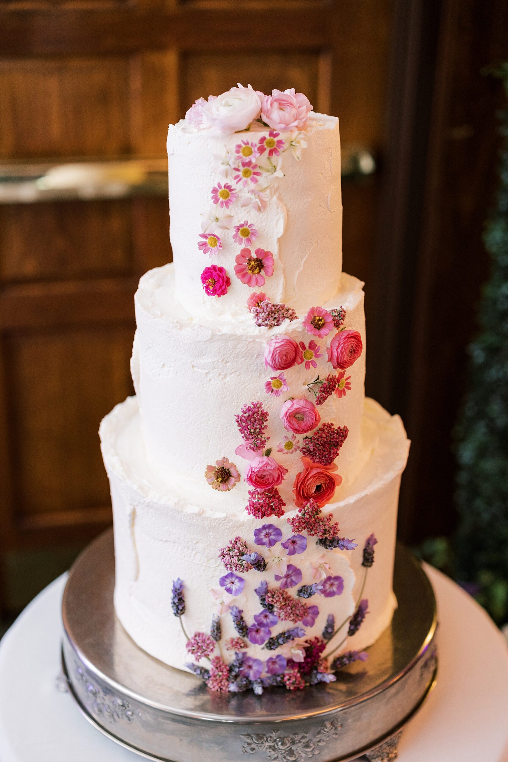 tiered wedding cake with cascading ombre pink flowers 