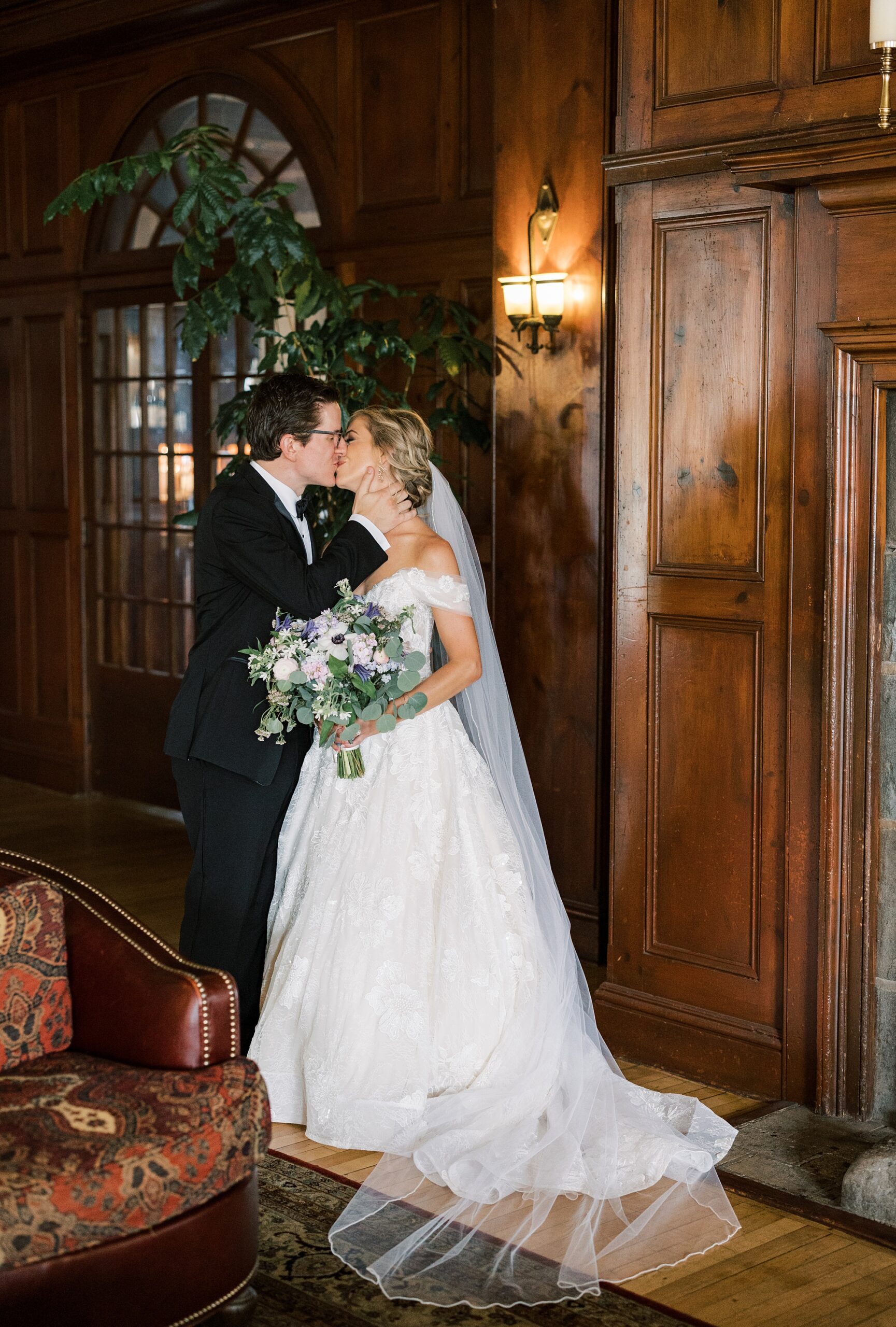 newlyweds kiss during wedding portraits inside Skytop Lodge