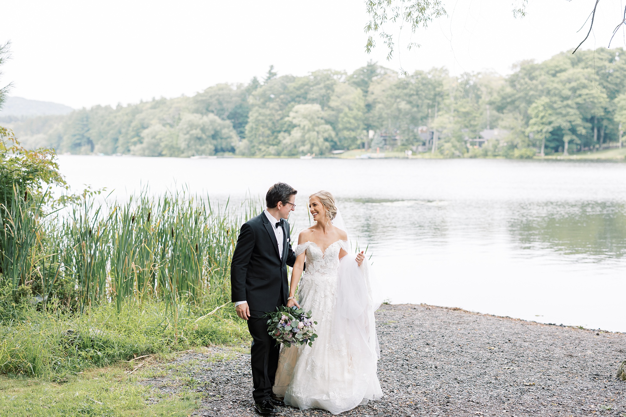 bride and groom laugh walking by lake at Skytop Lodge 