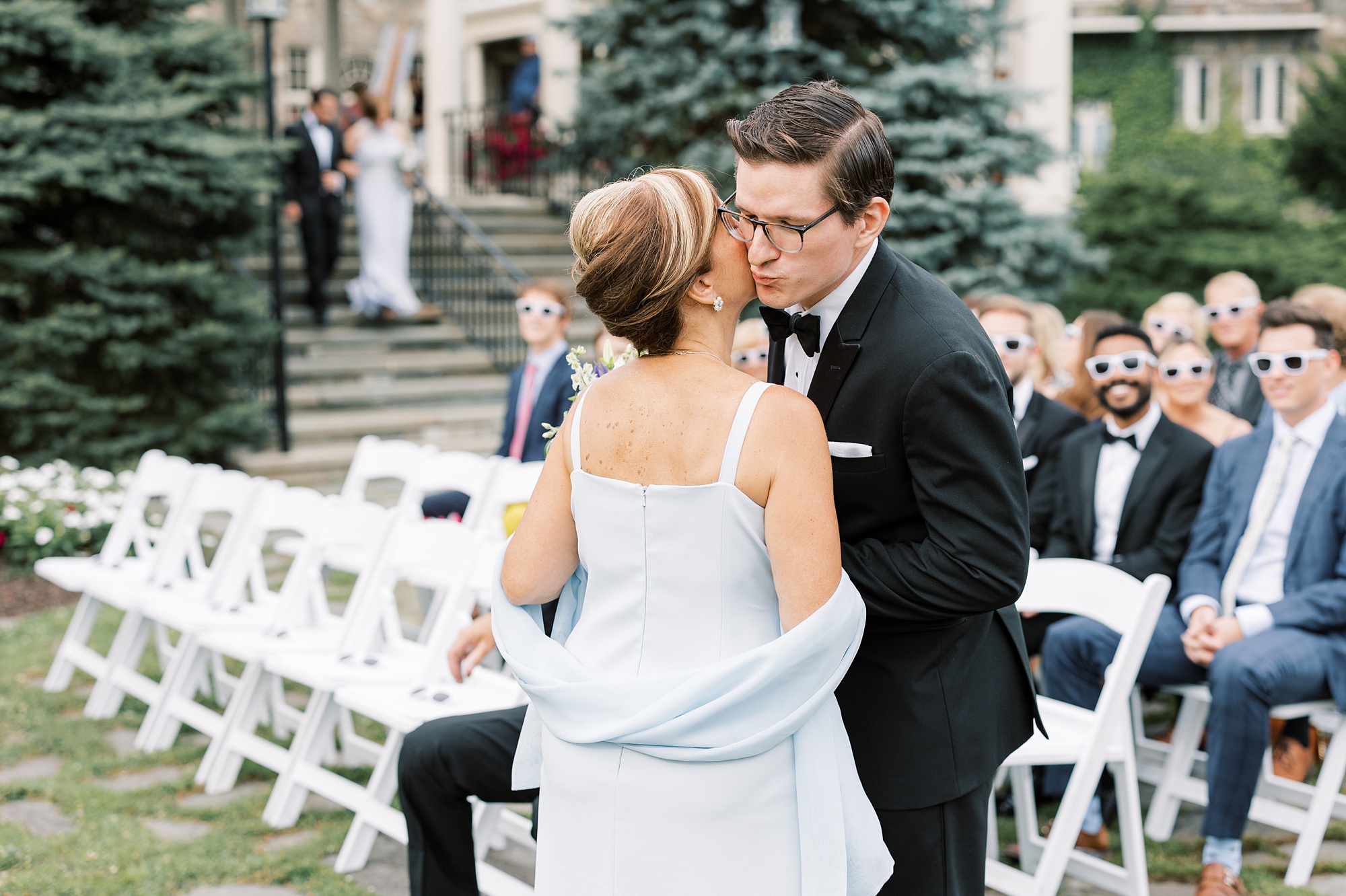 groom kisses mom's cheek during wedding ceremony on lawn at Skytop Lodge