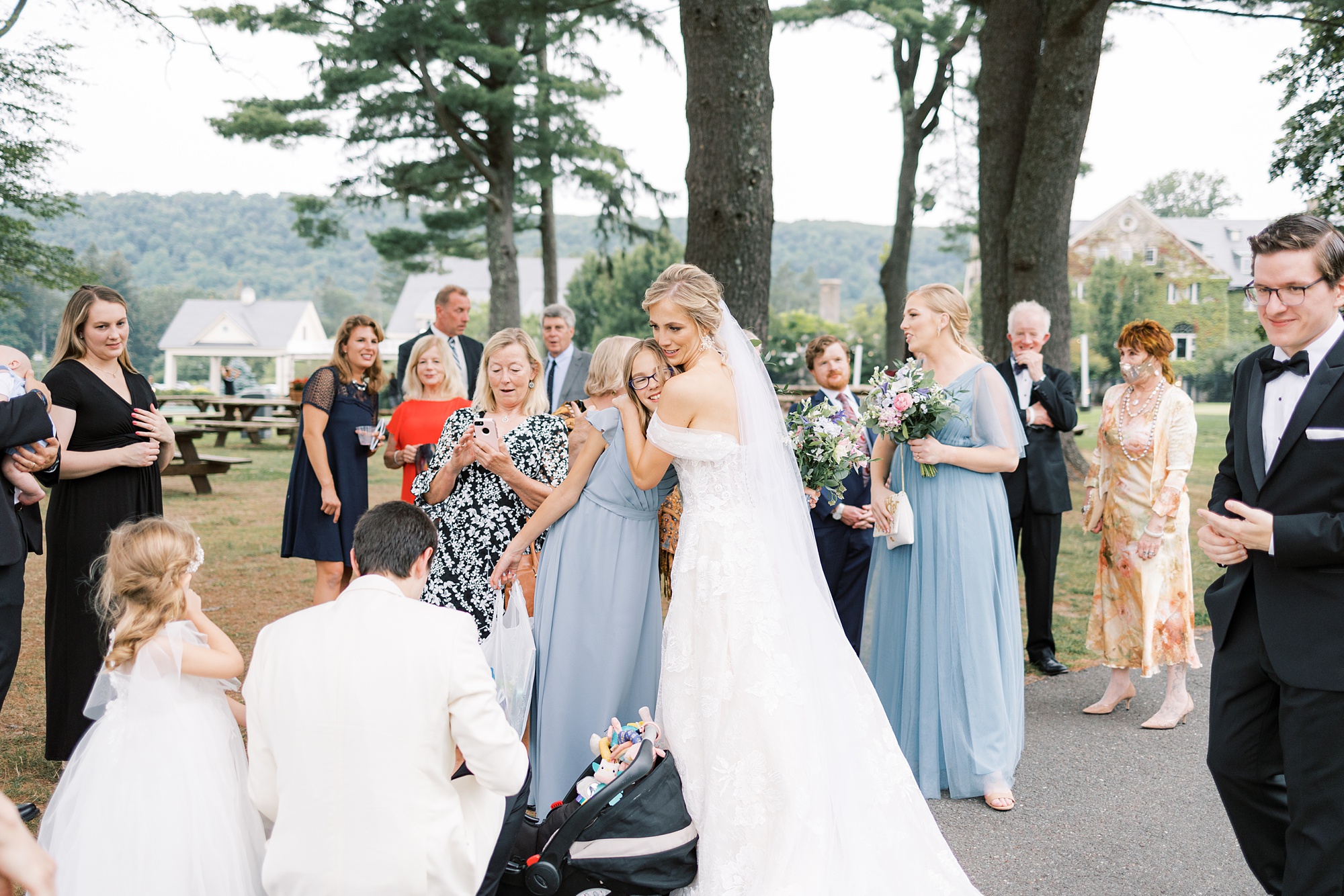 bride hugs bridesmaid after wedding ceremony on lawn at Skytop Lodge