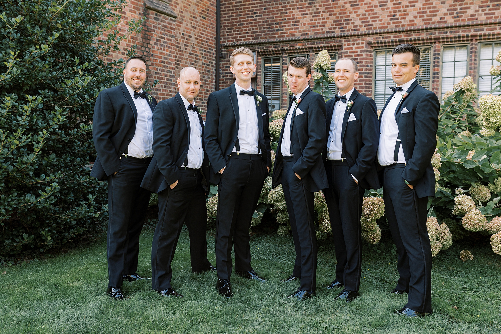 groom stands with groomsmen in black suits at Aldie Mansion