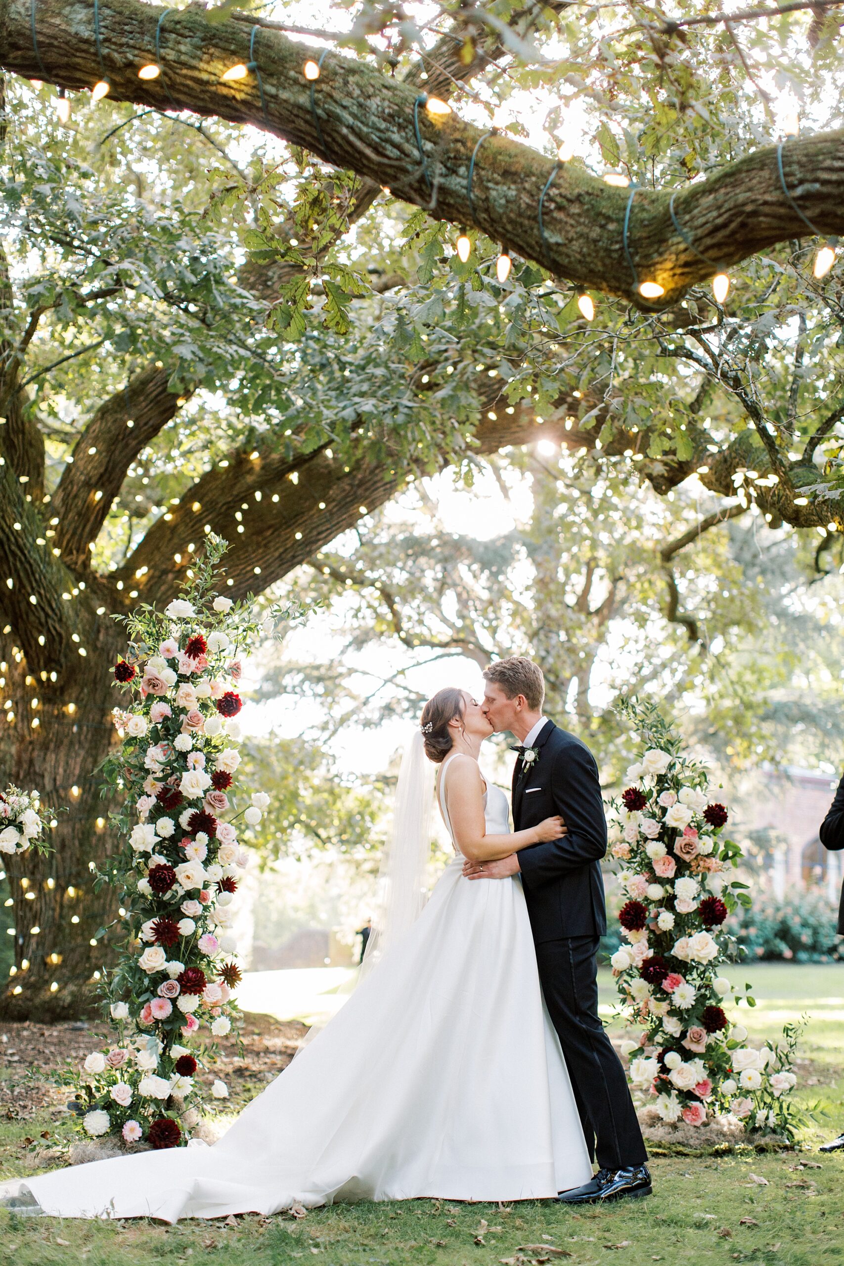 bride and groom kiss under oak tree at Aldie Mansion
