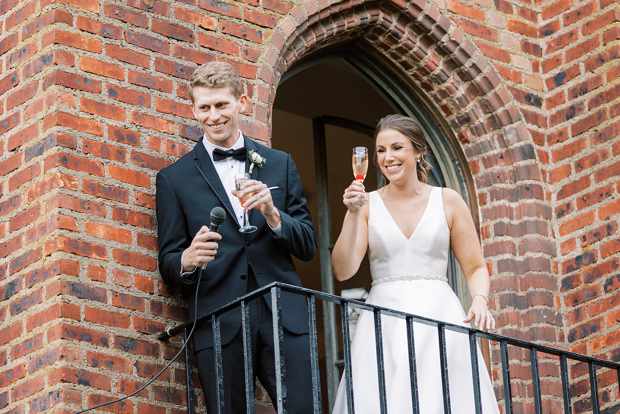 bride and groom give speech on courtyard balcony at Aldie Mansion