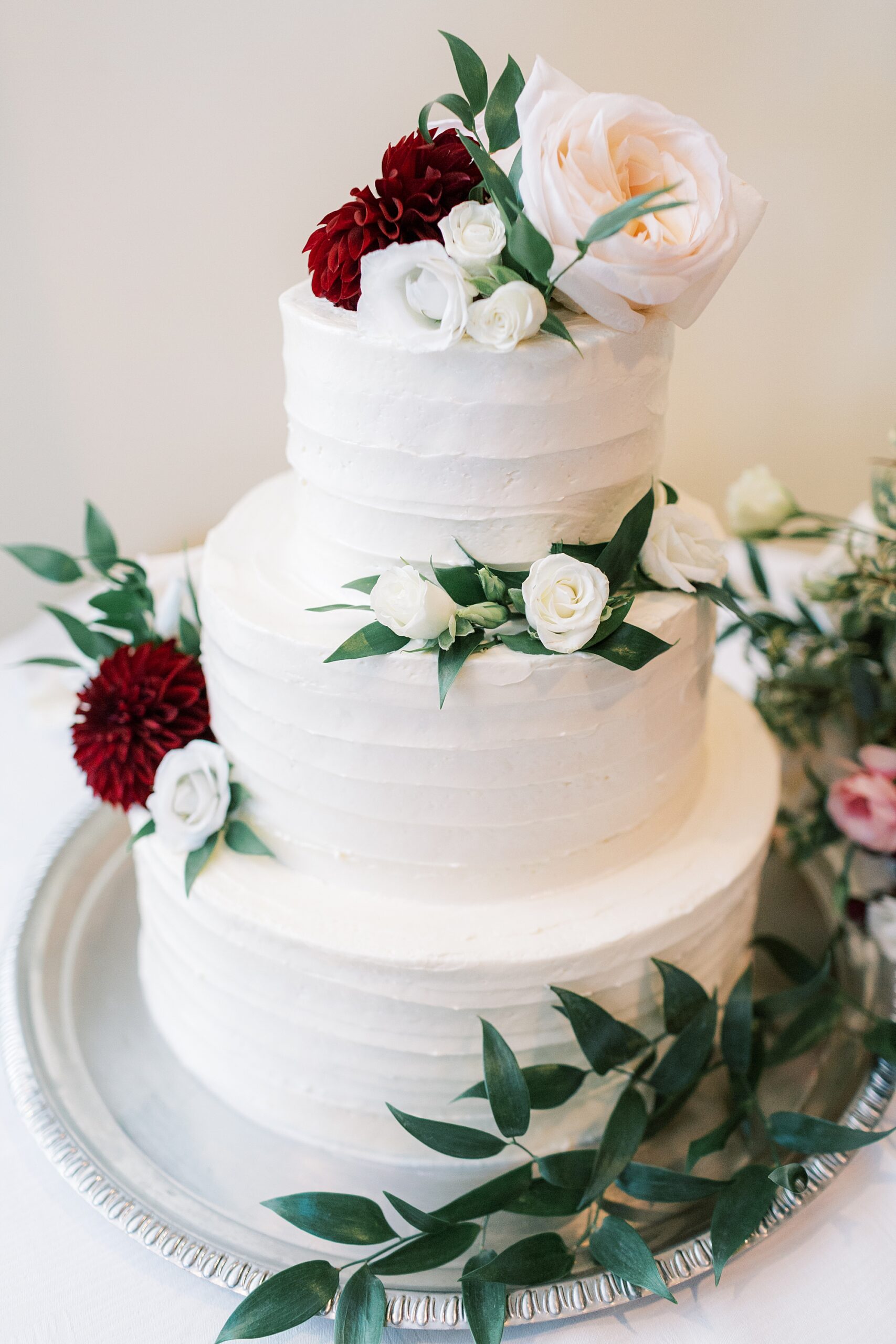 tiered wedding cake with ivory and red roses during Philadelphia PA