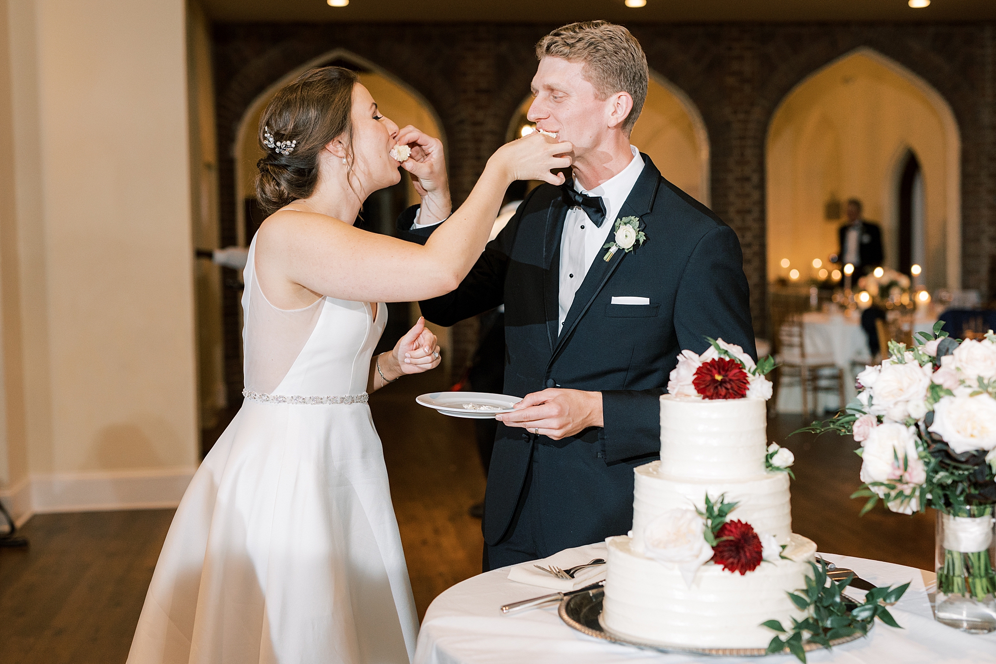 bride and groom feed each other wedding cake during PA wedding reception 