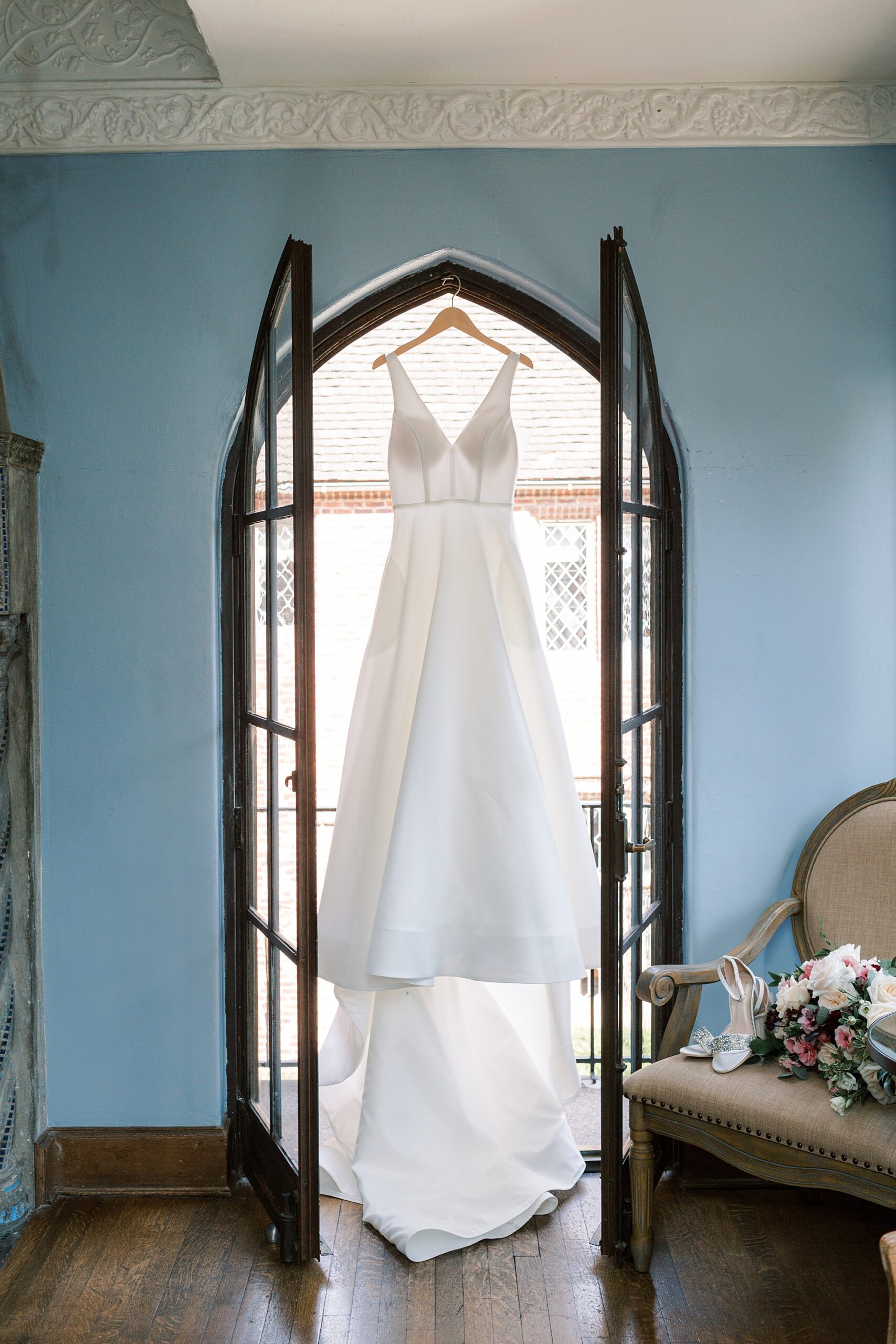 wedding dress hangs in window at Aldie Mansion