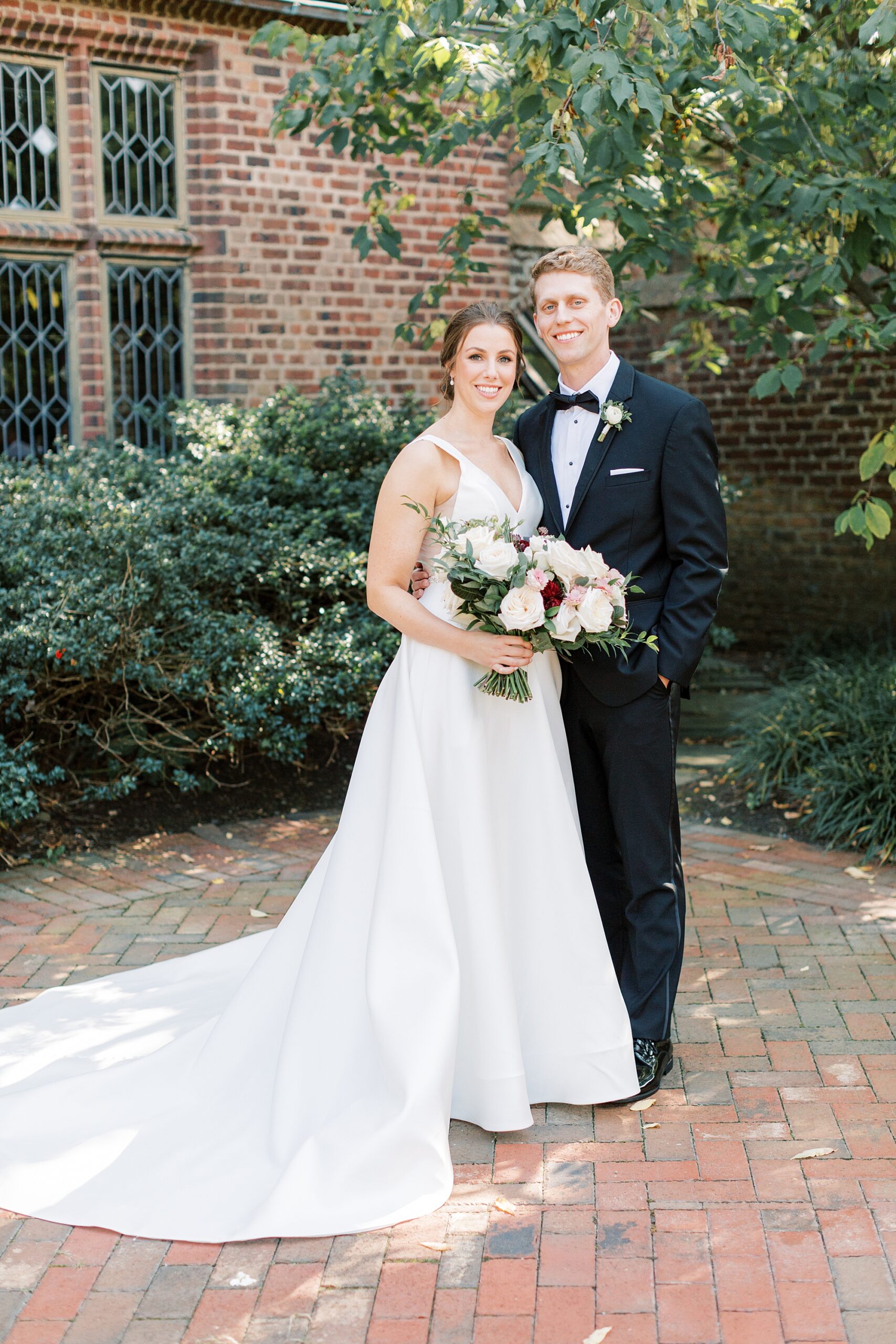 bride and groom stand in courtyard at Aldie Mansion
