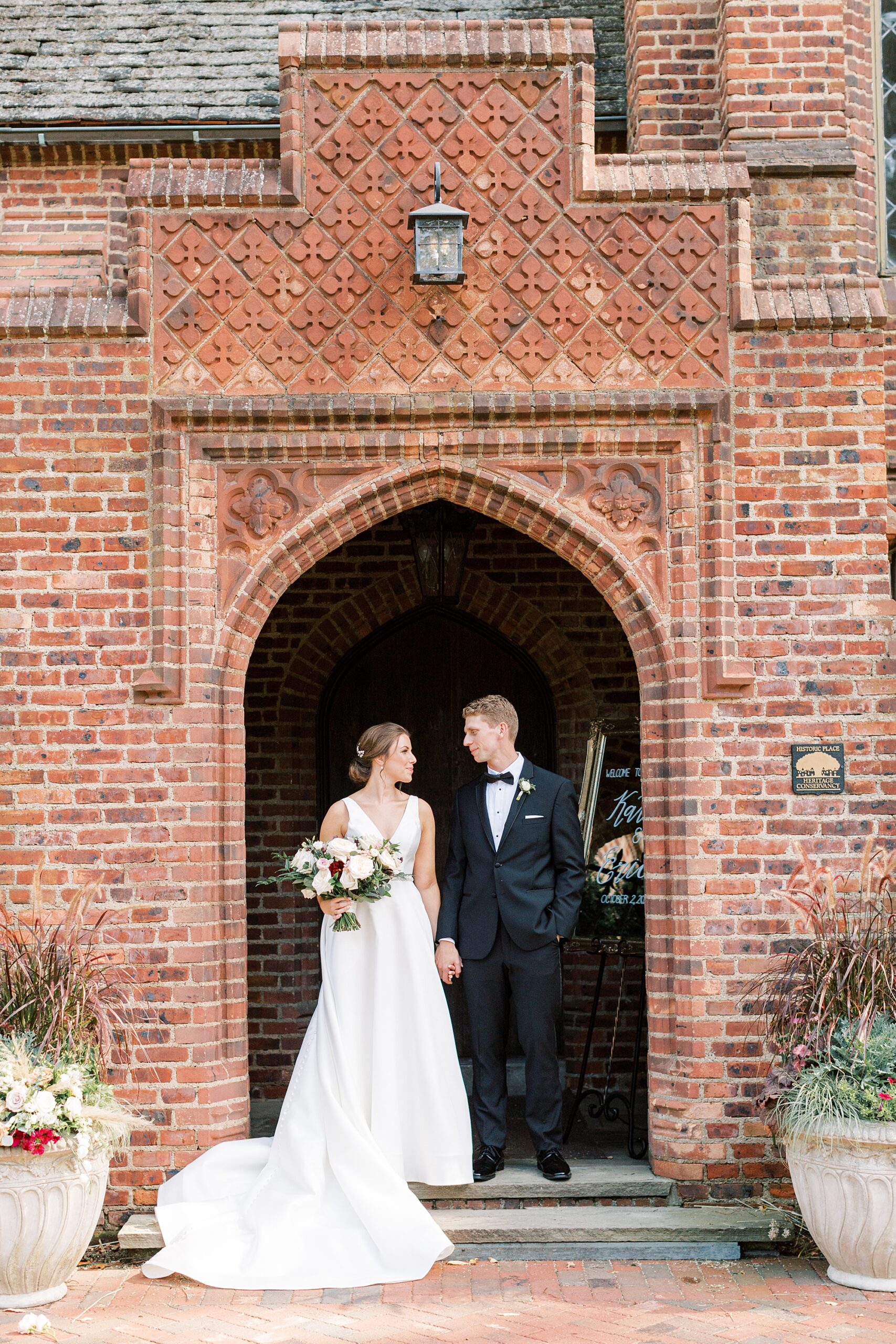 bride and groom stand in brick doorway at Aldie Mansion