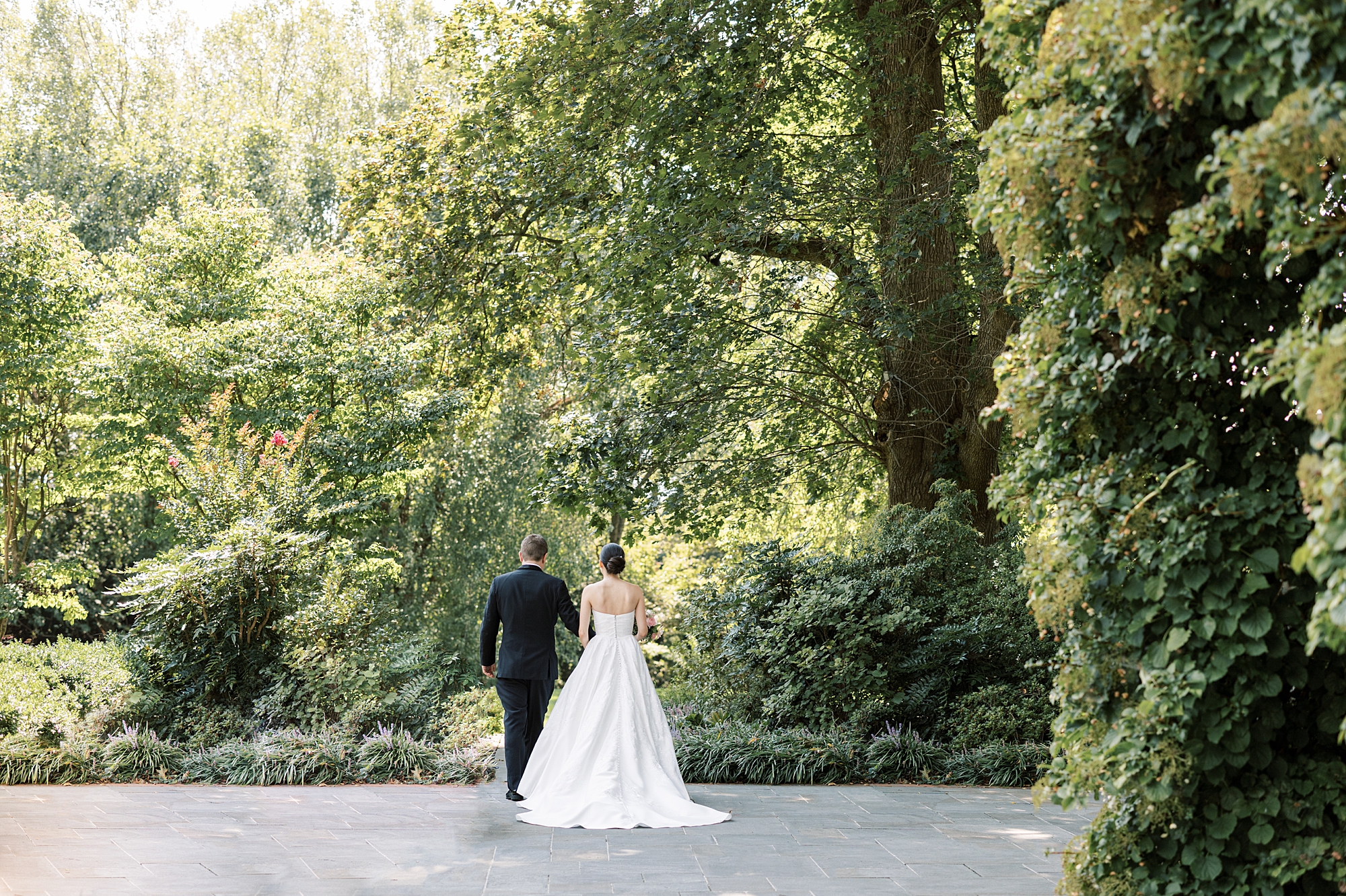bride and groom walk along path at Greenville Country Club