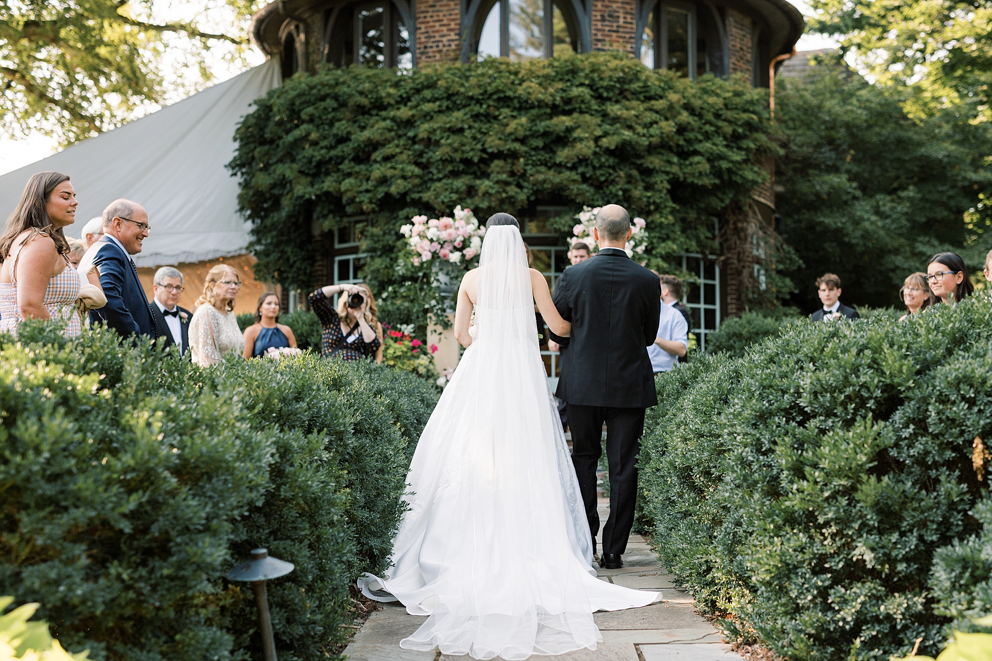 bride enters wedding ceremony in garden at Greenville Country Club