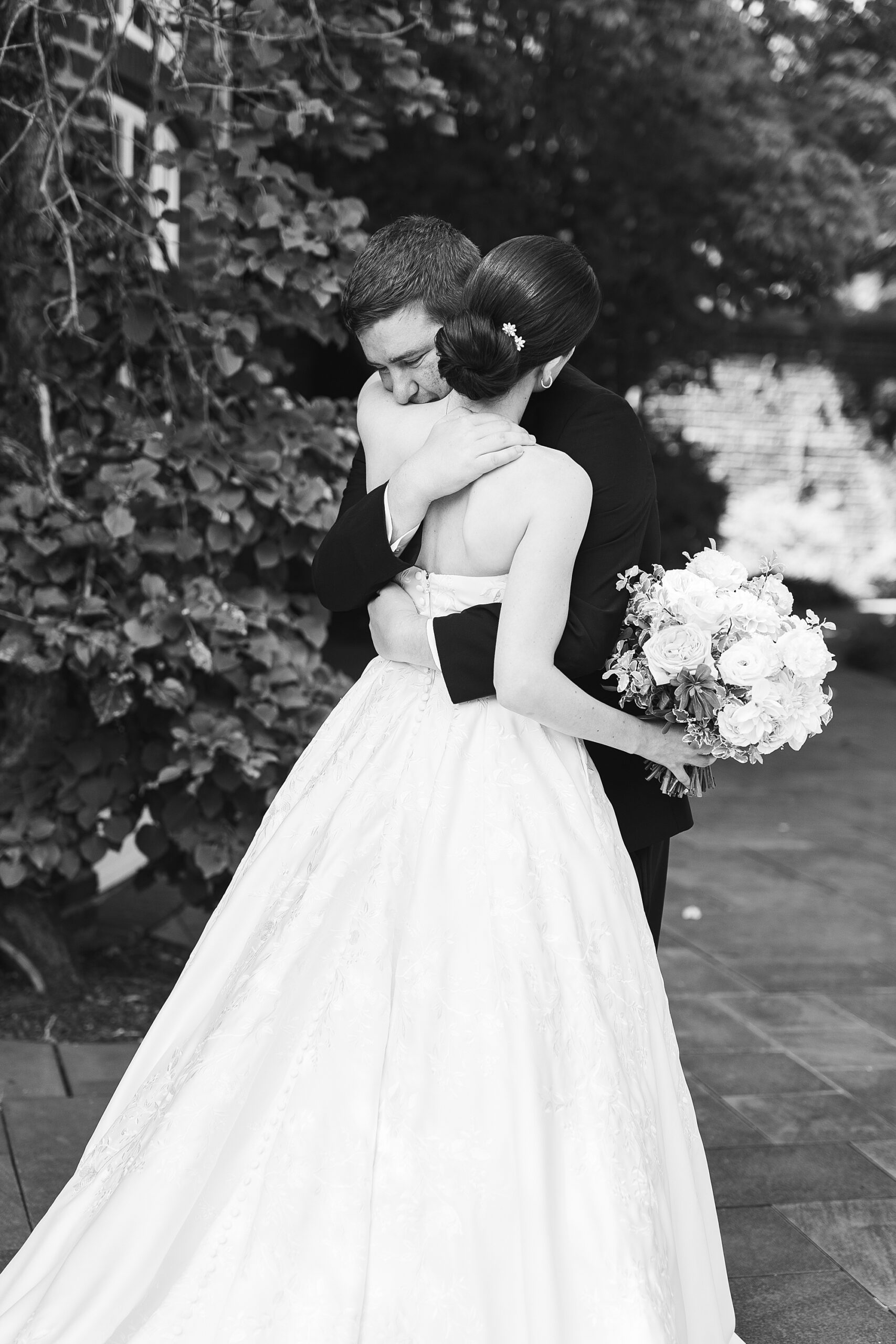 black and white photo of bride and groom hugging during first look at Greenville Country Club
