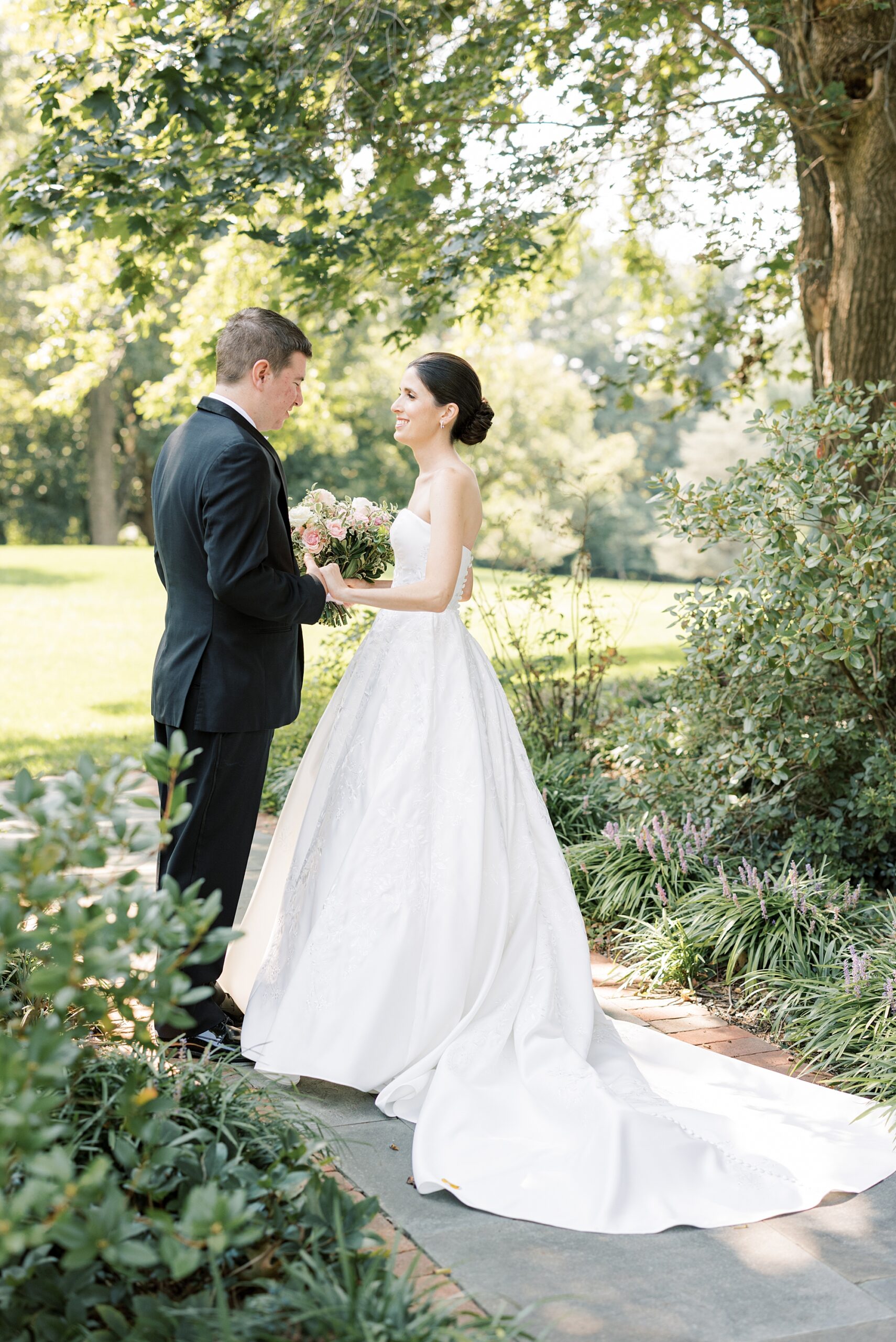 bride and groom laugh together in garden at Greenville Country Club
