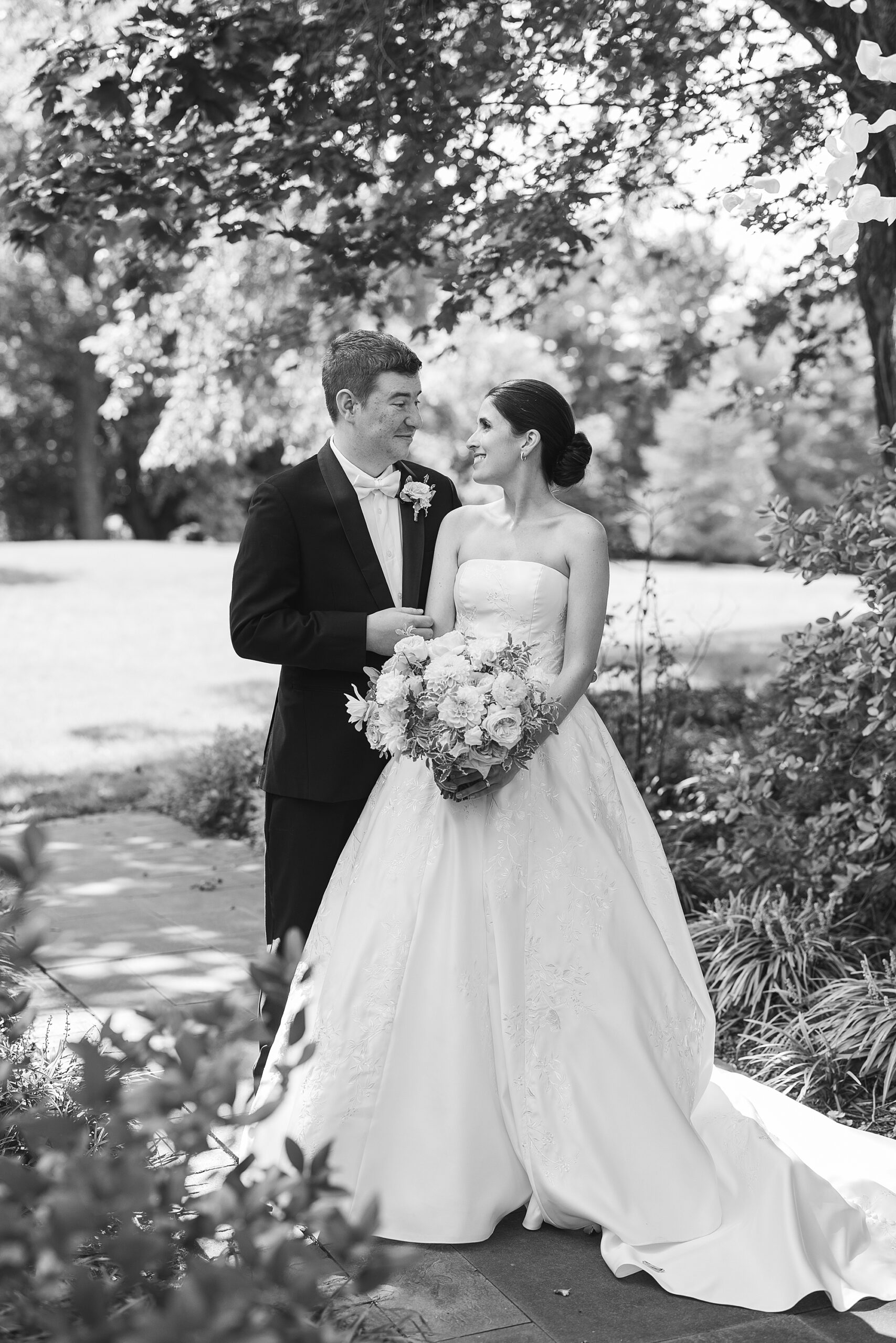 bride and groom look at each other standing in garden at Greenville Country Club