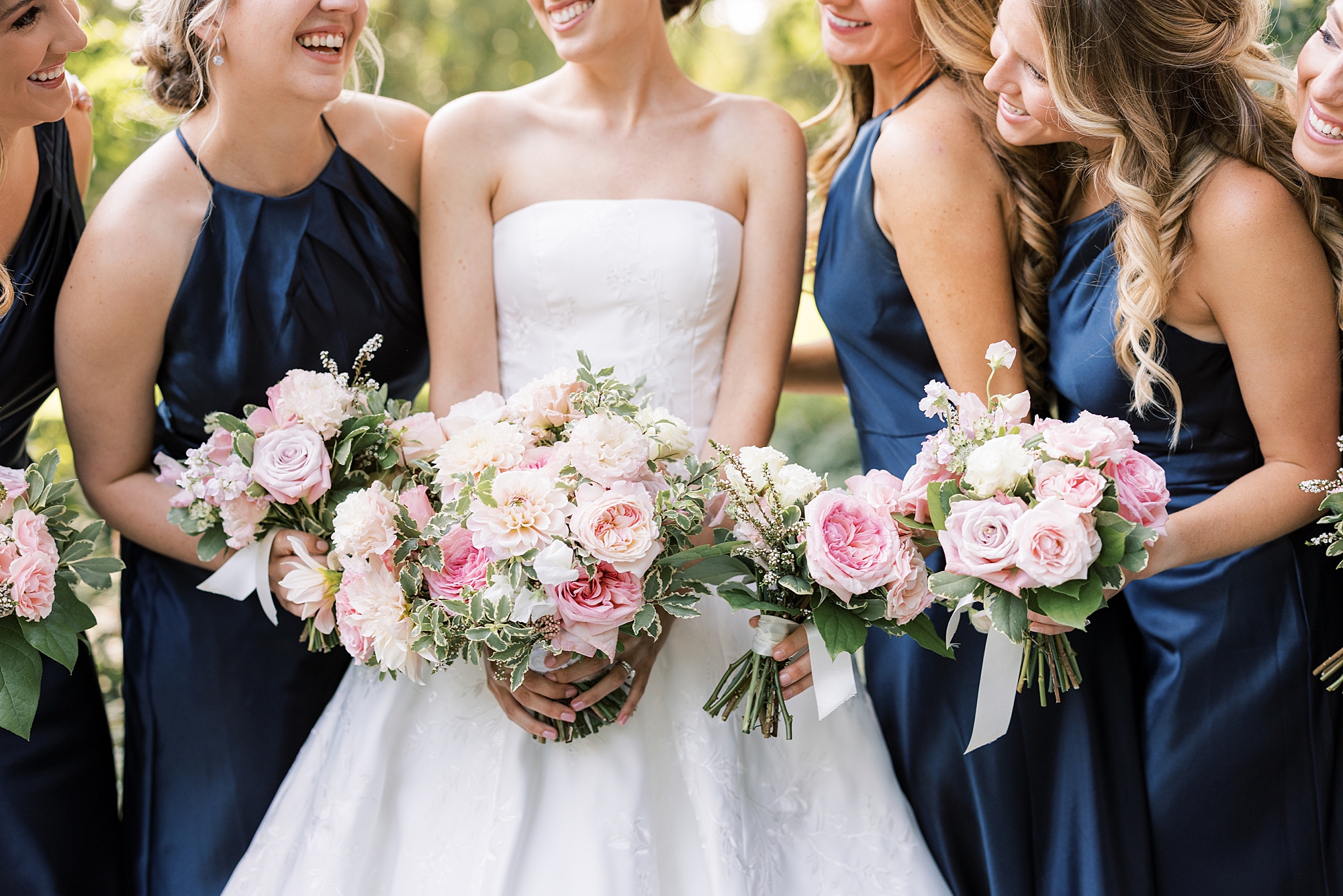 bride and bridesmaids hold pink and white bouquets at Greenville Country Club