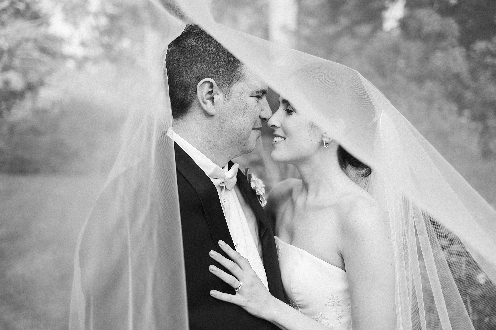 bride and groom hug close under bride's veil at Greenville Country Club