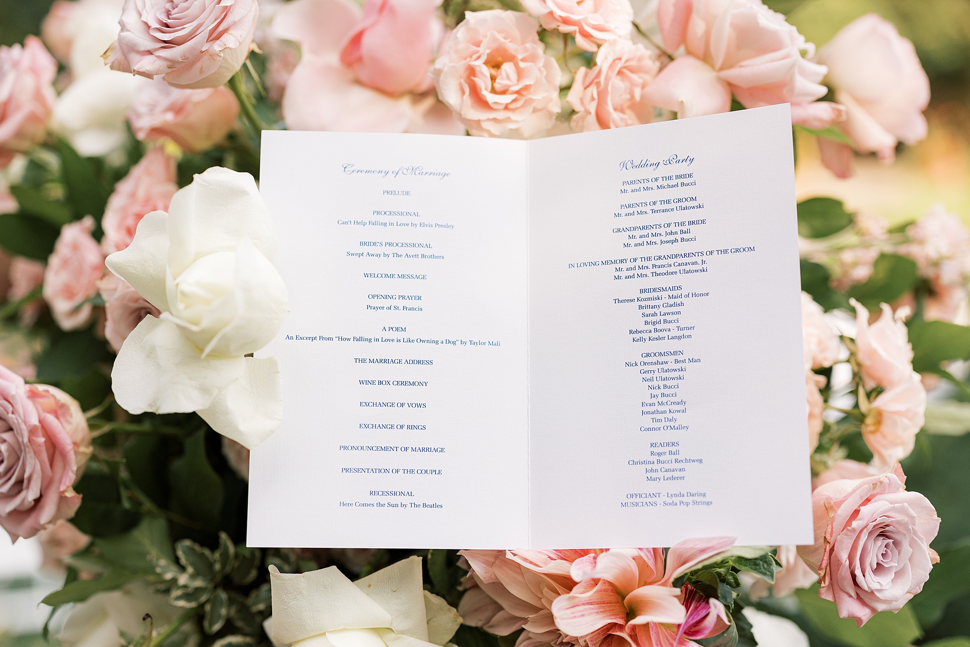 ceremony program rests on pink peonies and roses 