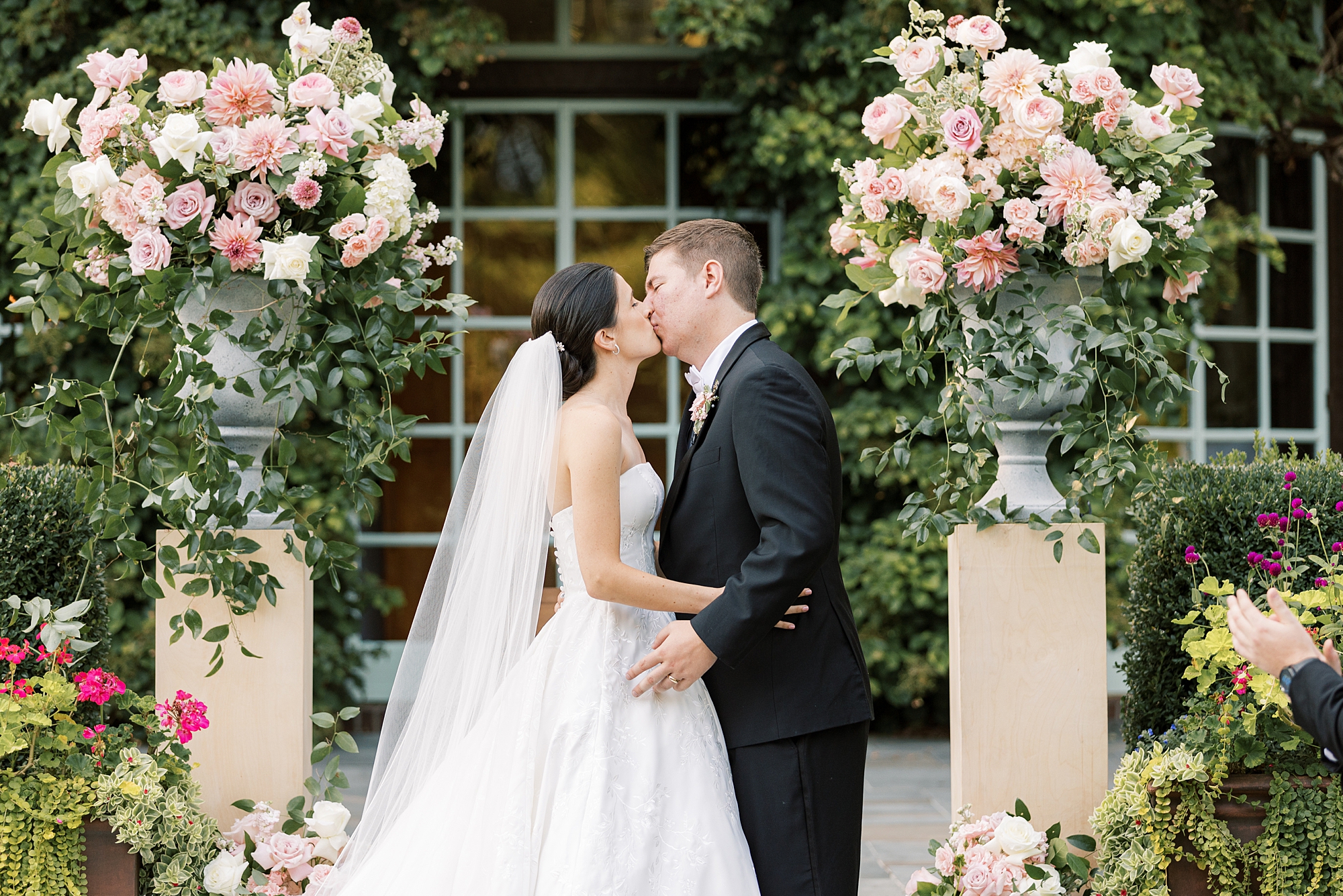 bride and groom kiss at ceremony in gardens at Greenville Country Club