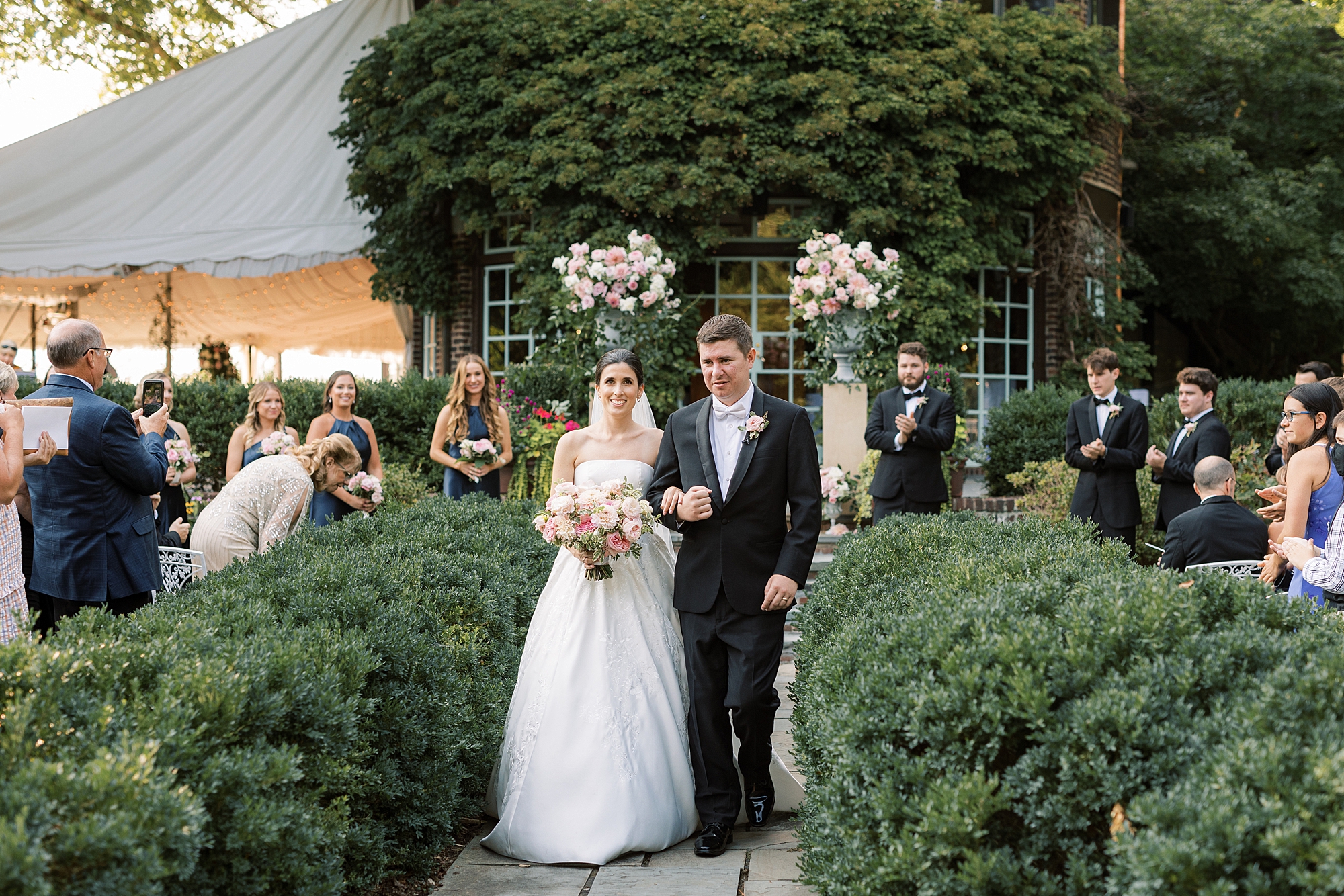 newlyweds leave ceremony in gardens at Greenville Country Club