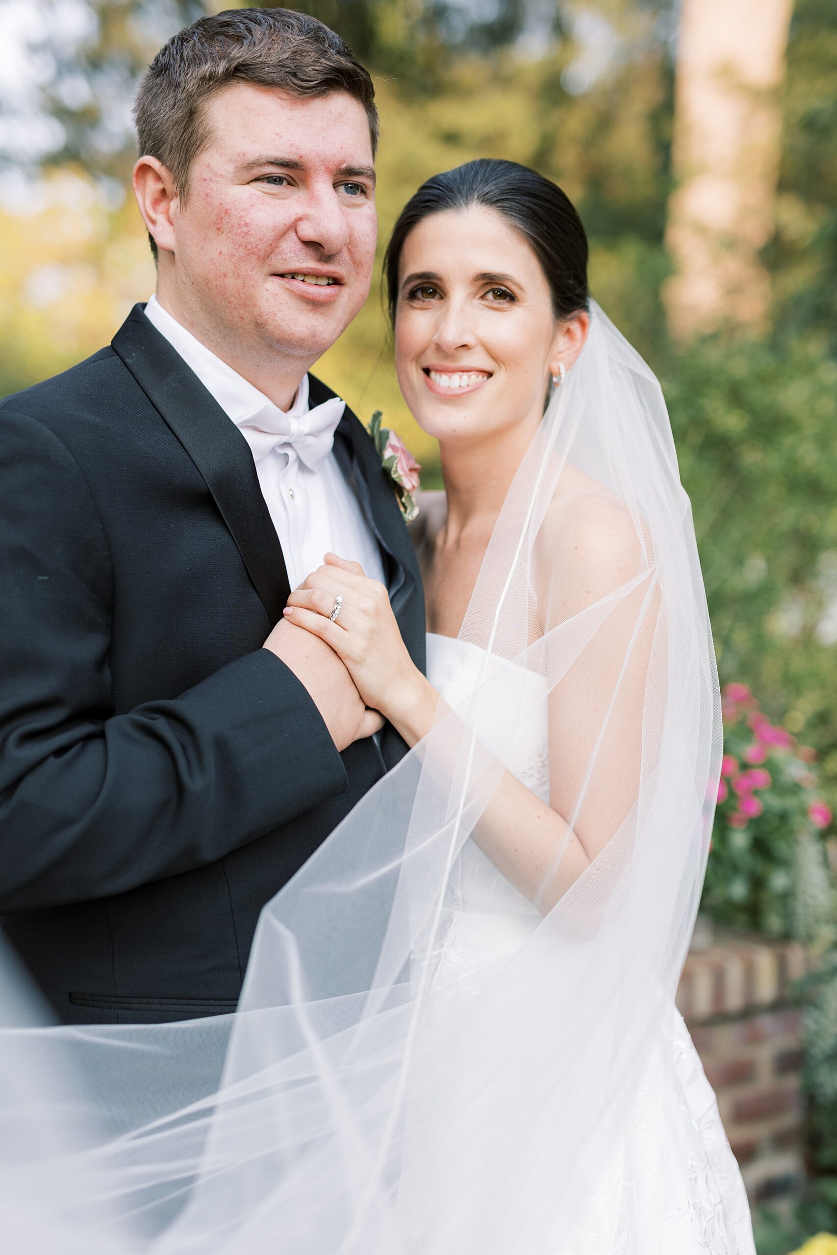 bride and groom hug close with bride's veil around them at Greenville Country Club