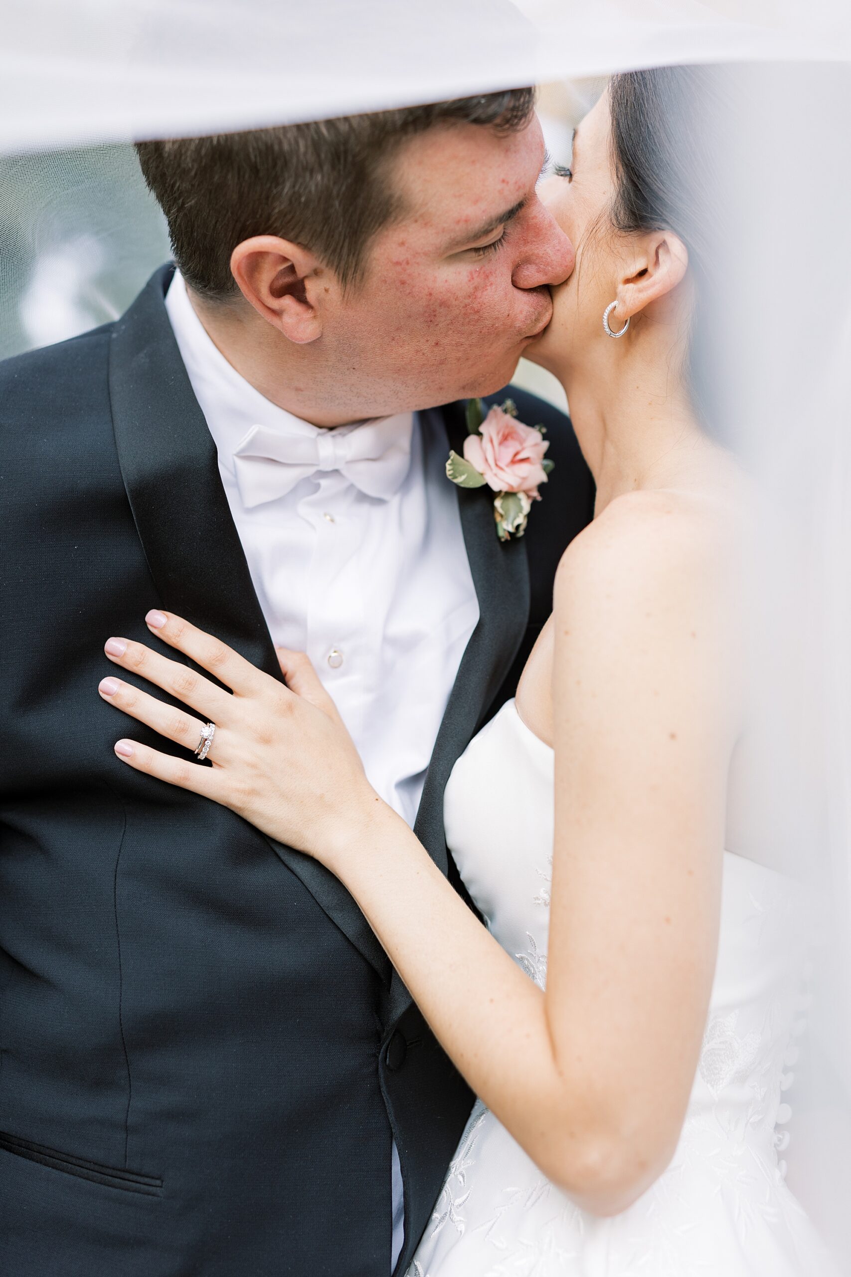 newlyweds kiss under bride's veil during Greenville Country Club wedding photos 