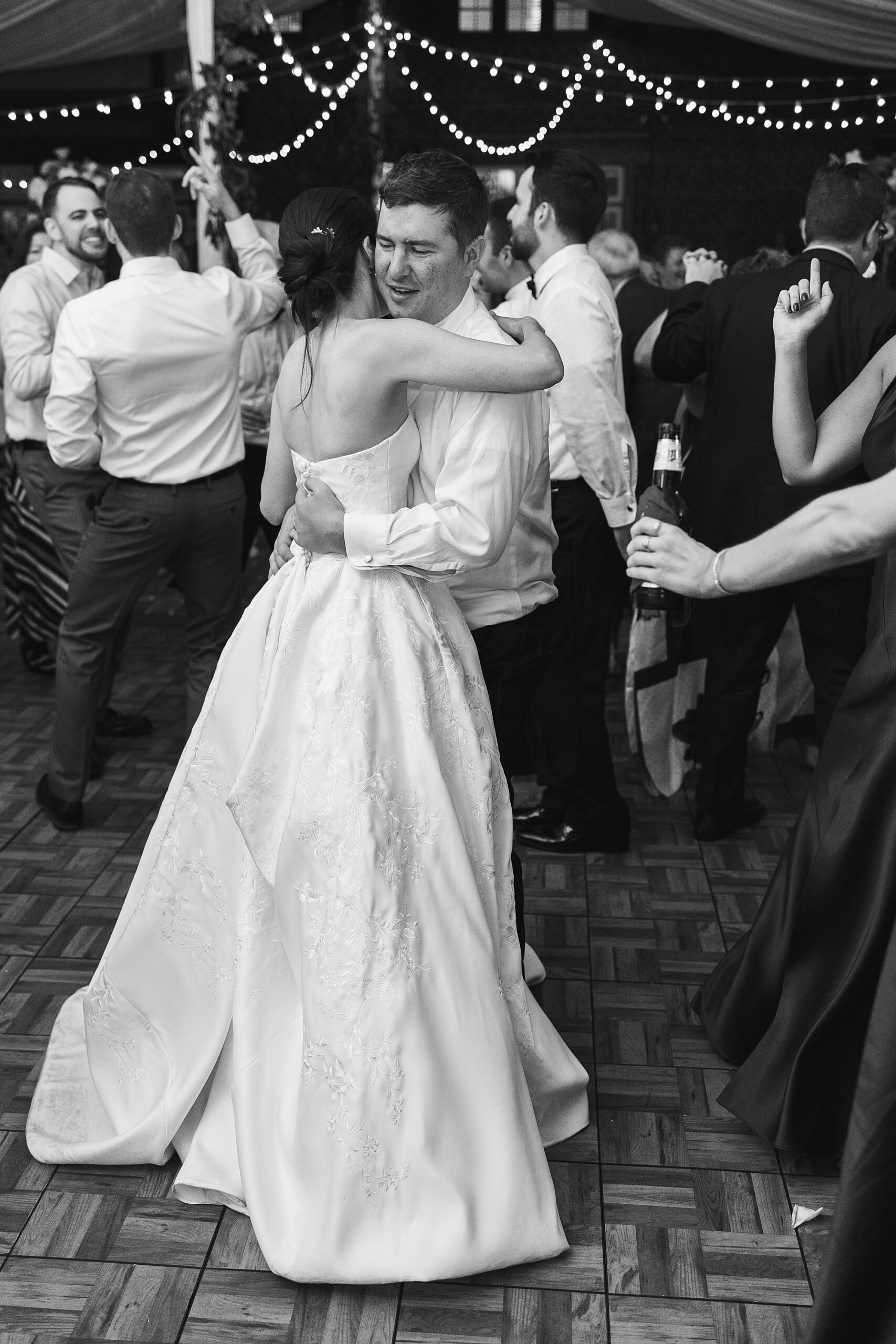 bride and groom hug on dance floor at Greenville Country Club